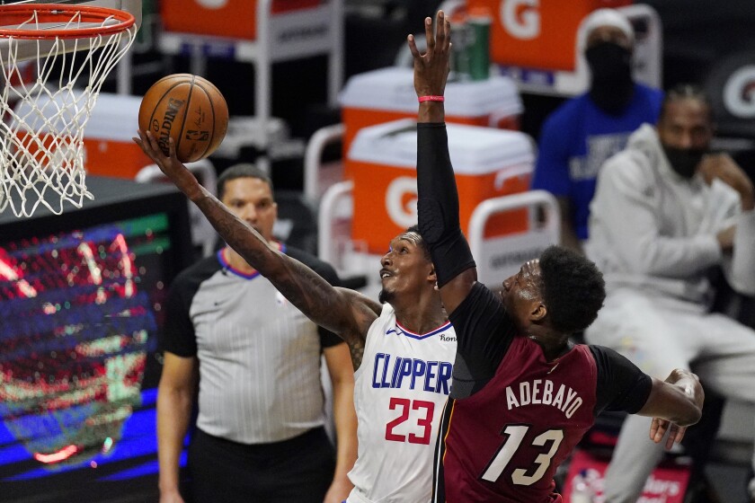 Clippers guard Lou Williams, left, shoots in front of Miami Heat center Bam Adebayo.