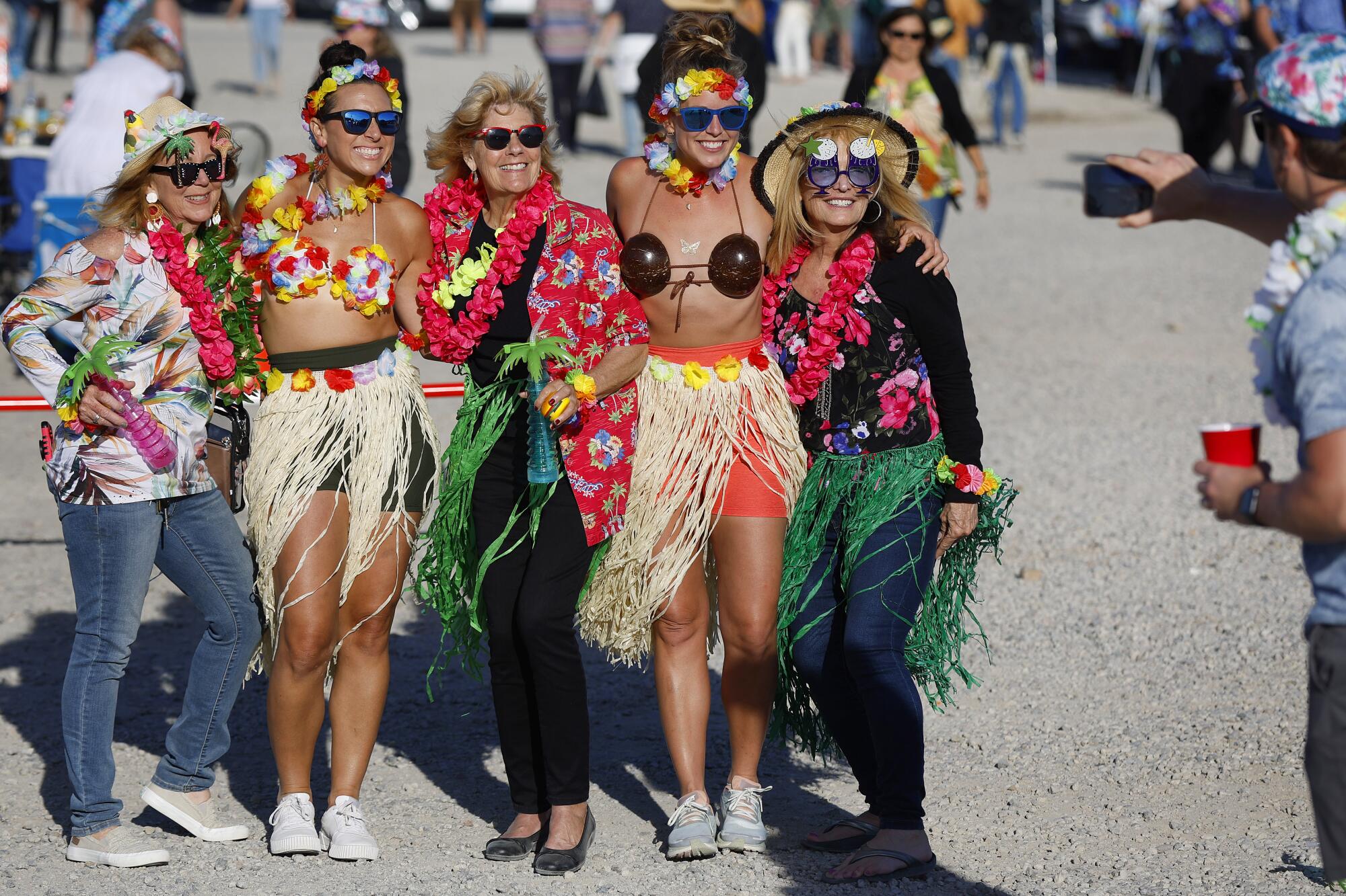 Jimmy Buffett fans take a photo in the parking lot at Snapdragon Stadium.