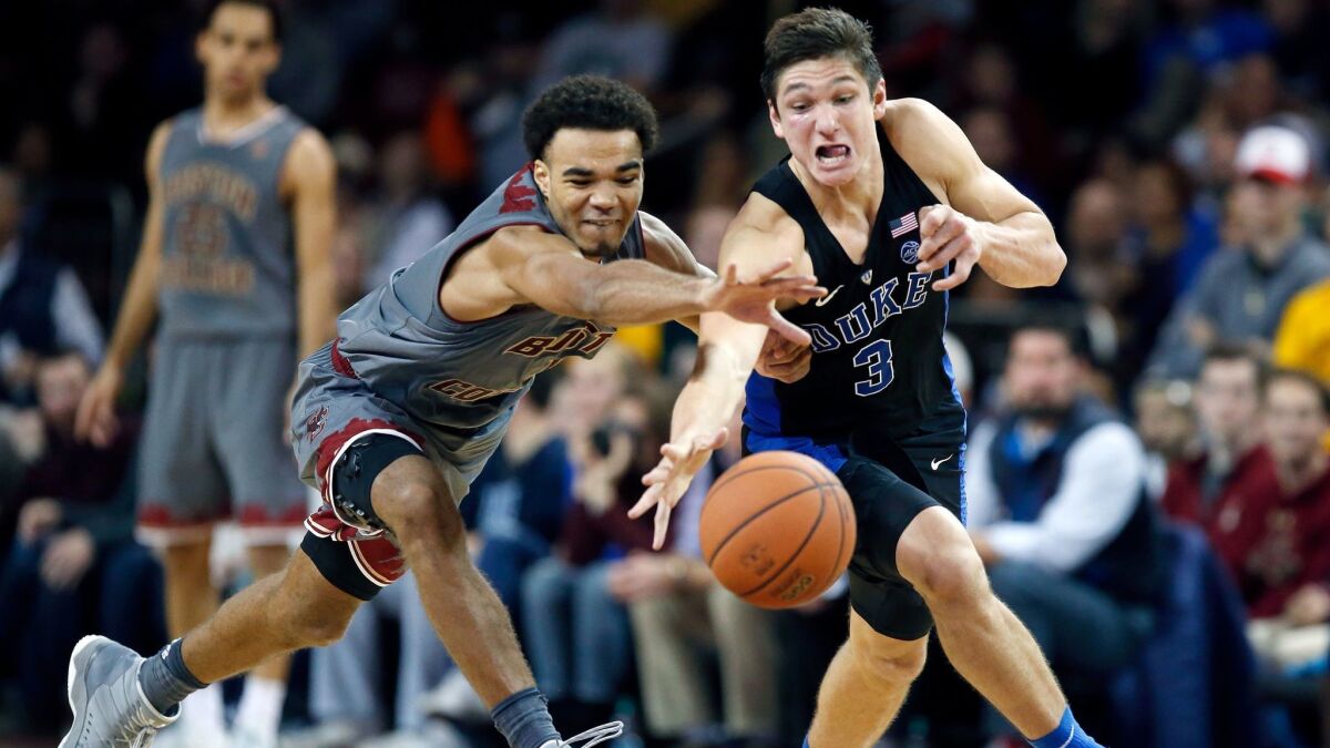 Boston College's Jerome Robinson and Duke's Grayson Allen chase a loose ball during the second half.