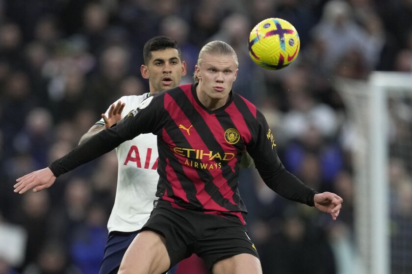 Manchester City's Erling Haaland, front, controls the ball in front of Tottenham's Cristian Romero during an English Premier League soccer match between Tottenham Hotspur v Manchester City at the Tottenham Hotspur Stadium in London, Sunday, Feb. 5, 2023. (AP Photo/Kin Cheung)