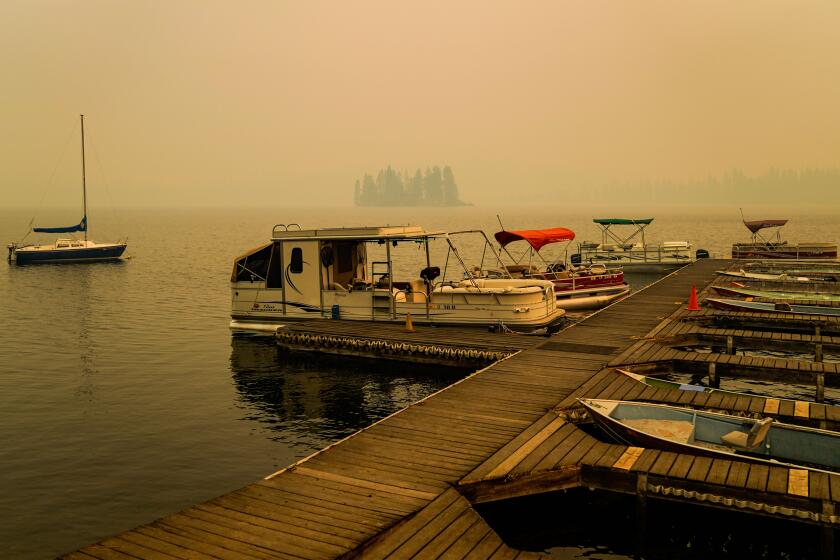 HUNTINGTON LAKE, CA - SEPTEMBER 09: Smoke from the Creek Fire hangs in the air as a boat sits moored off shore on Wednesday, Sept. 9, 2020 in Huntington Lake, CA. (Kent Nishimura / Los Angeles Times)