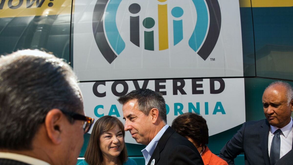 Covered California Executive Director Peter V. Lee, center, on Nov. 1, 2015.
