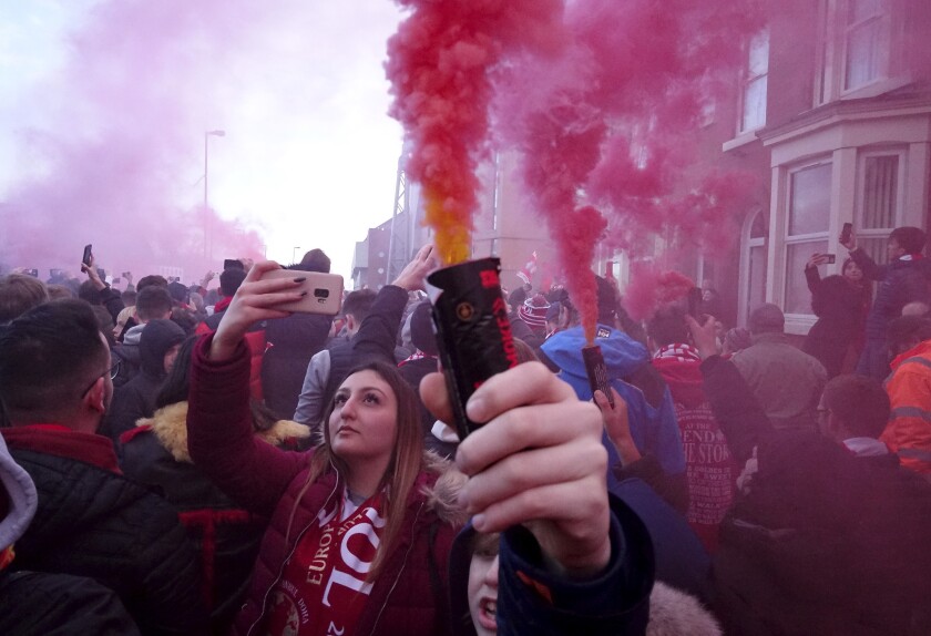 Football supporters set off flares before the English Premier League soccer match between Liverpool and Manchester United near Anfield Stadium in Liverpool, Sunday, Jan. 19, 2020.(AP Photo/Jon Super)