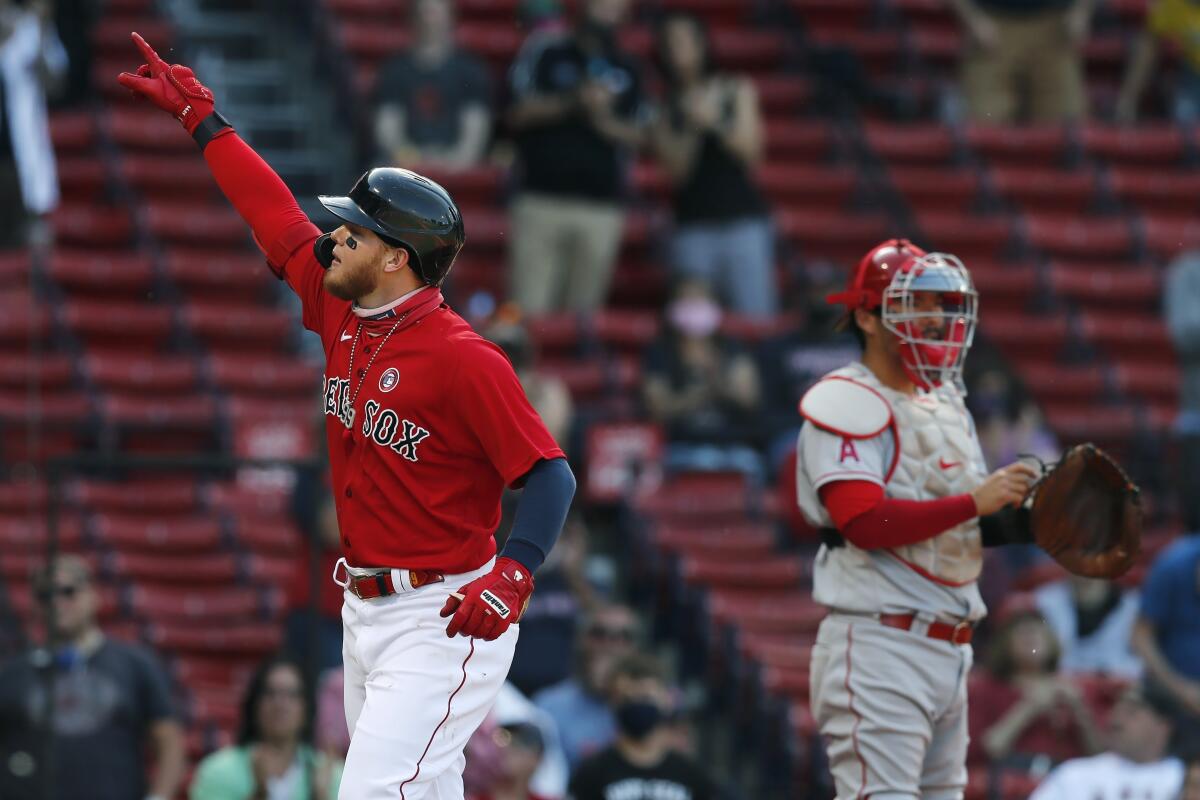 Boston Red Sox's Alex Verdugo, left, celebrates his solo home run as Los Angeles Angels' Kurt Suzuki stands at home plate during the first inning of a baseball game, Saturday, May 15, 2021, in Boston. (AP Photo/Michael Dwyer)