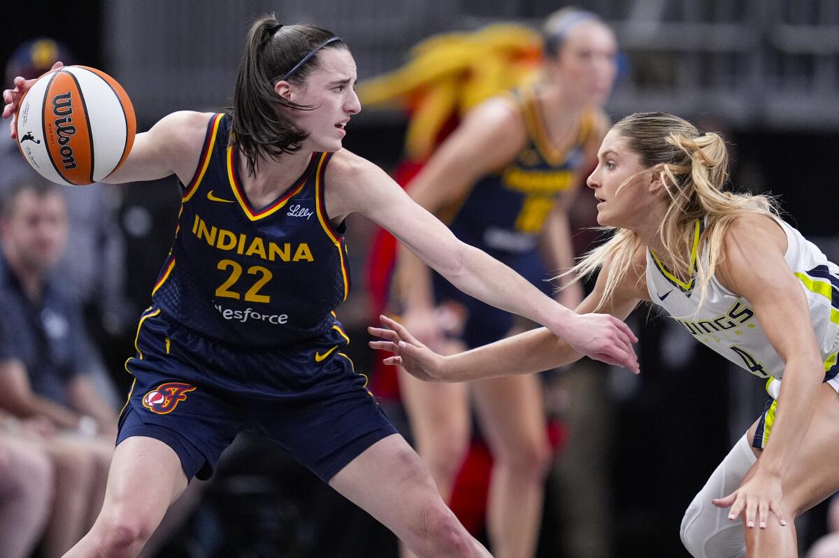 Fever guard Caitlin Clark, left, is being defended by Wings' Jacy Sheldon