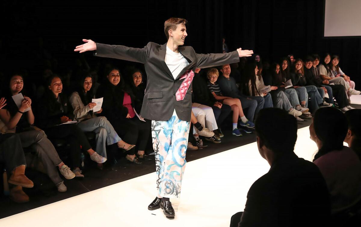 Student model Paul Cauffman gets the audience clapping as he walks the runway during the fashion show at Sage Hill School.
