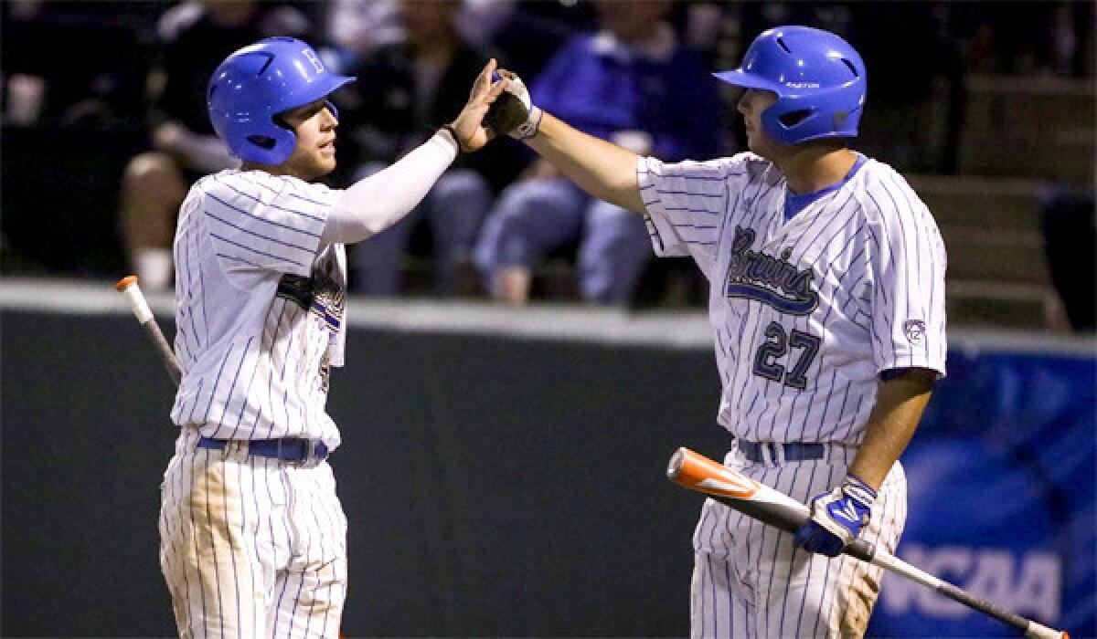 UCLA's Eric Filia and Pat Gallagher celebrate a run during the Bruins' 6-0 victory over San Diego to advance to a super-regional matchup against Cal State Fullerton.