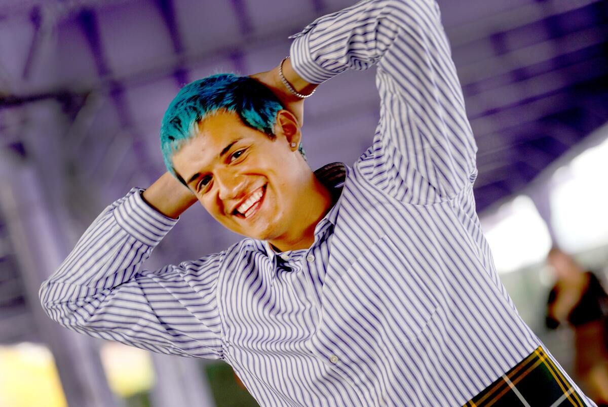 A man with blue hair, smiling.