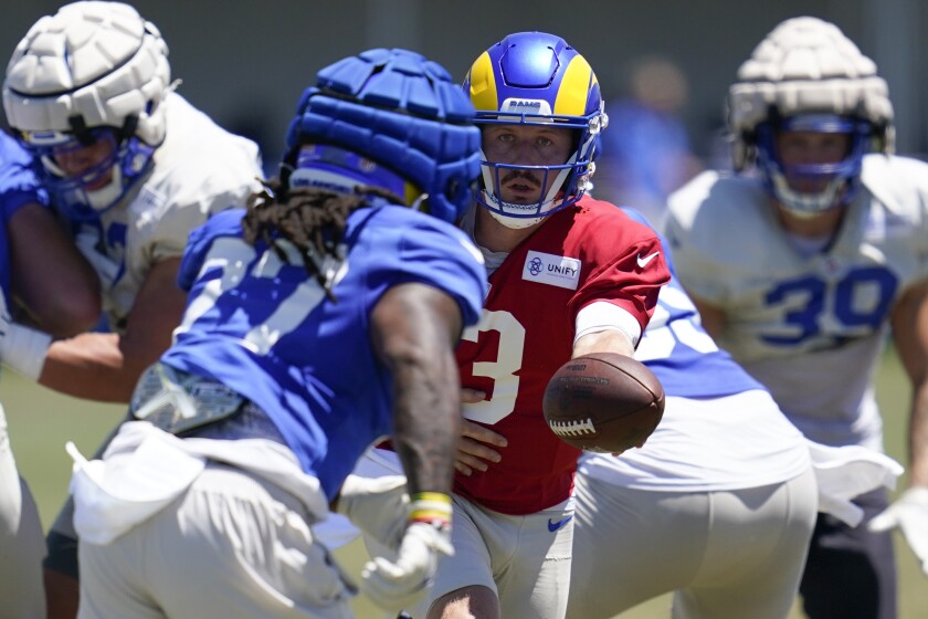 Rams quarterback John Wolford hands off to running back Darrell Henderson Jr. during a team practice on Aug. 6.