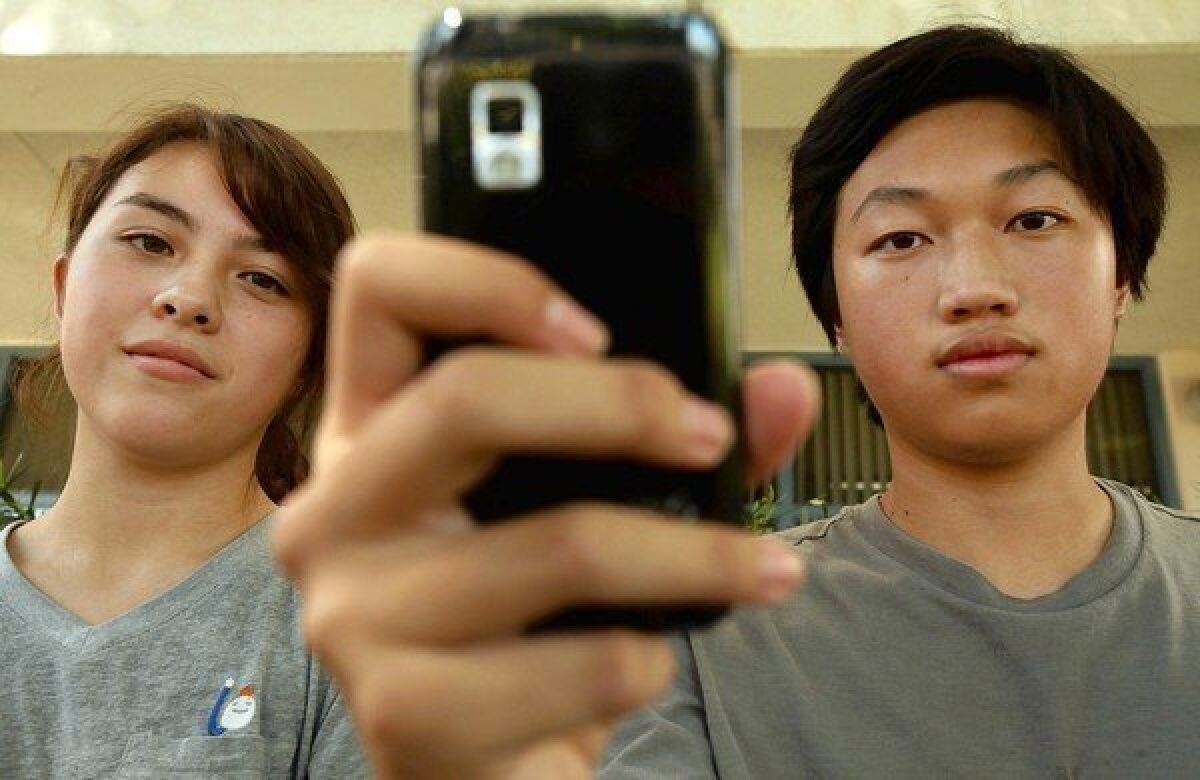 Young Cho, left, here with Hoover High classmate Christopher Chung, thinks the school district's monitoring program goes too far.
