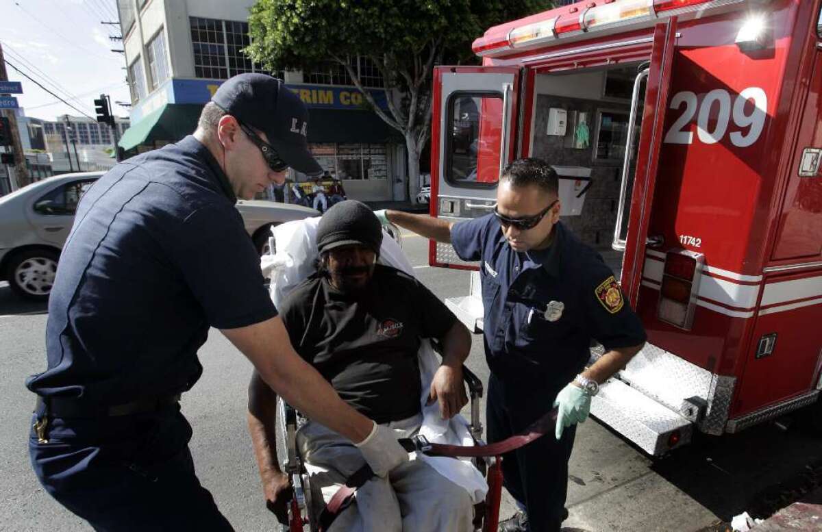 A file photo shows Los Angeles Fire Department paramedics helping a patient on Skid Row.