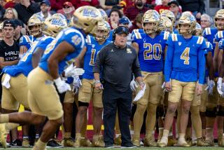 UCLA coach Chip Kelly reacts on the sidelines while standing alongside his players