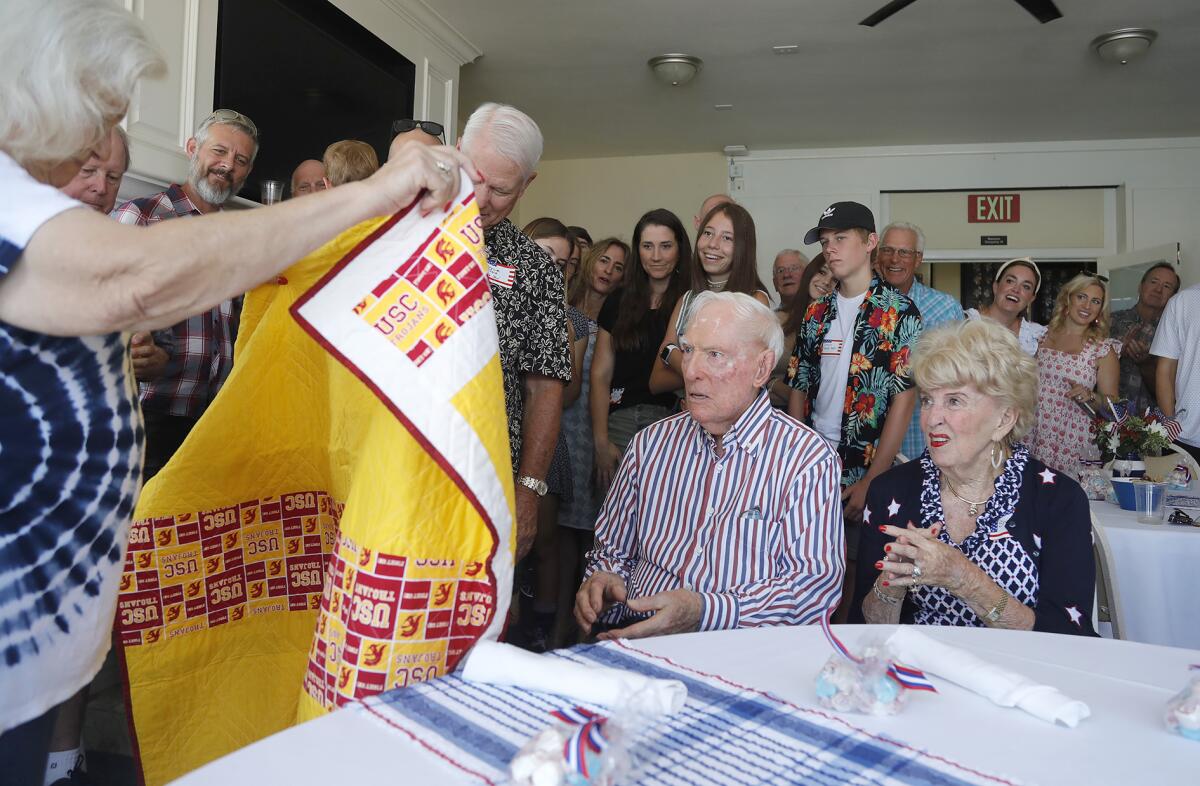 World War II veteran Joseph King, surrounded by extended family, is surprised with a quilt of valor by Barbara Winkler.