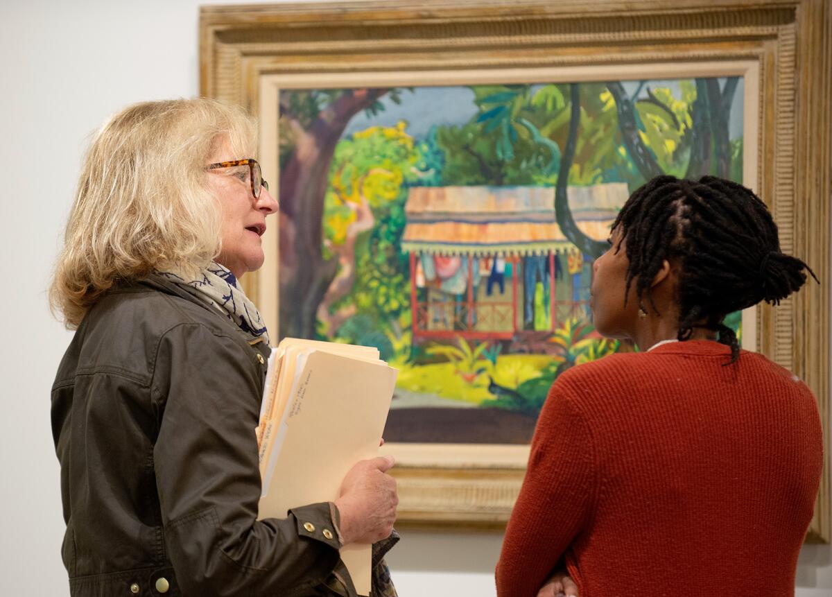 Victoria Gustafson, a docent for the Hilbert Museum of California Art, chats with a guest.