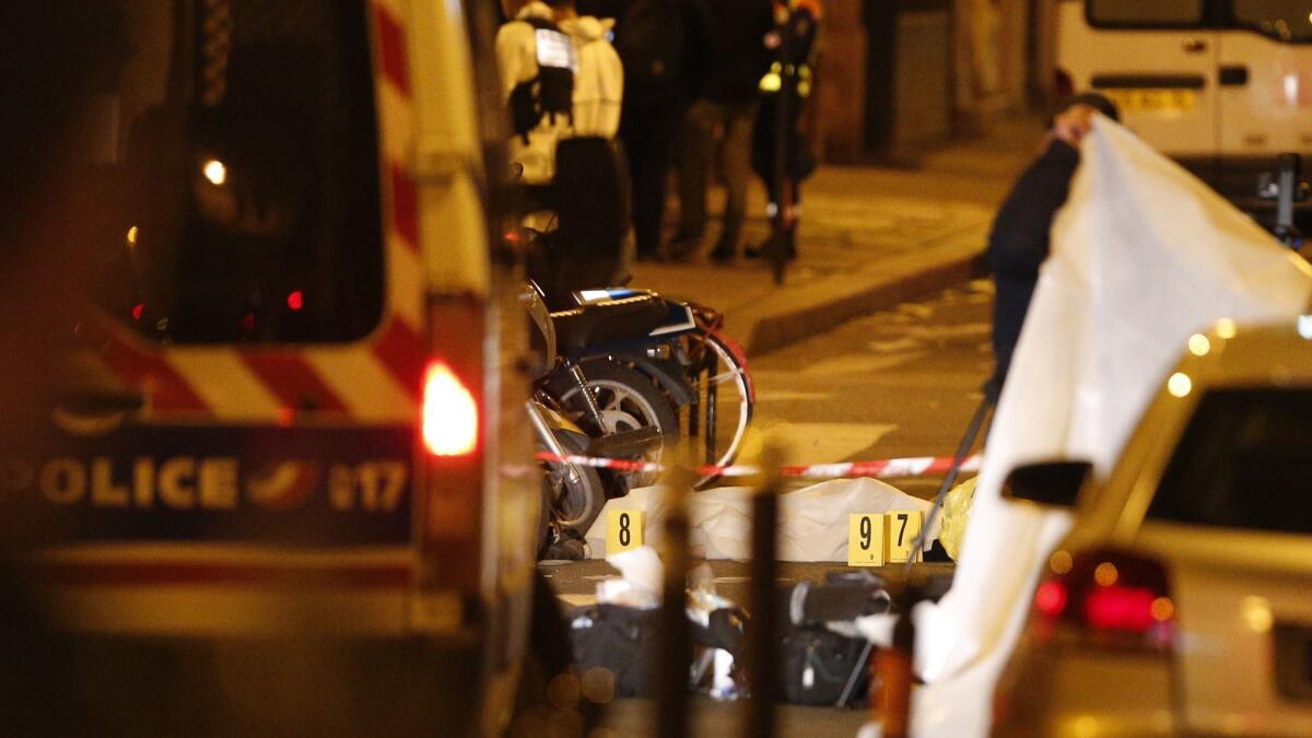 A body lies under a blanket after the knife attack Saturday in central Paris.