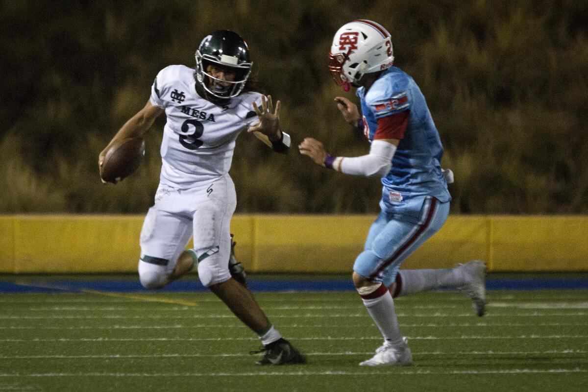 Costa Mesa quarterback Nick Burton runs the ball for a first down against Santa Ana in an Orange Coast League opener at Santa Ana Stadium on Thursday.