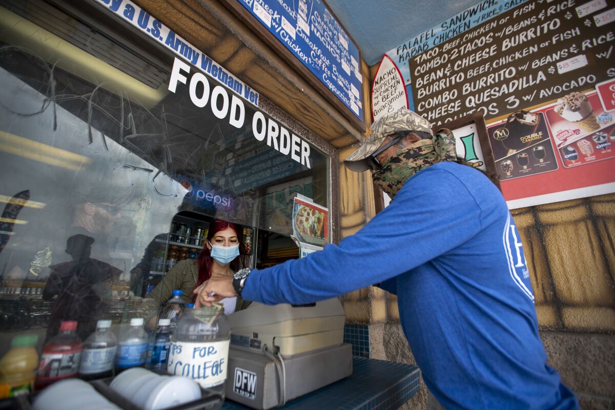 Aileen Delaportilla, left, a business major at Golden West College, receives a tip from customer Ron Mancillas of Fresno.