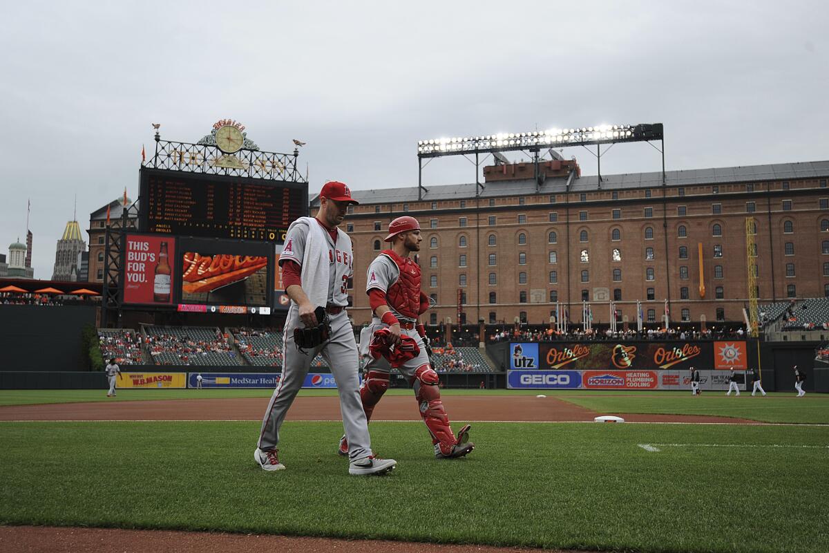 Matt Harvey, left, walks to the dugout with Angels teammate Jonathan Lucroy before a game in Baltimore.