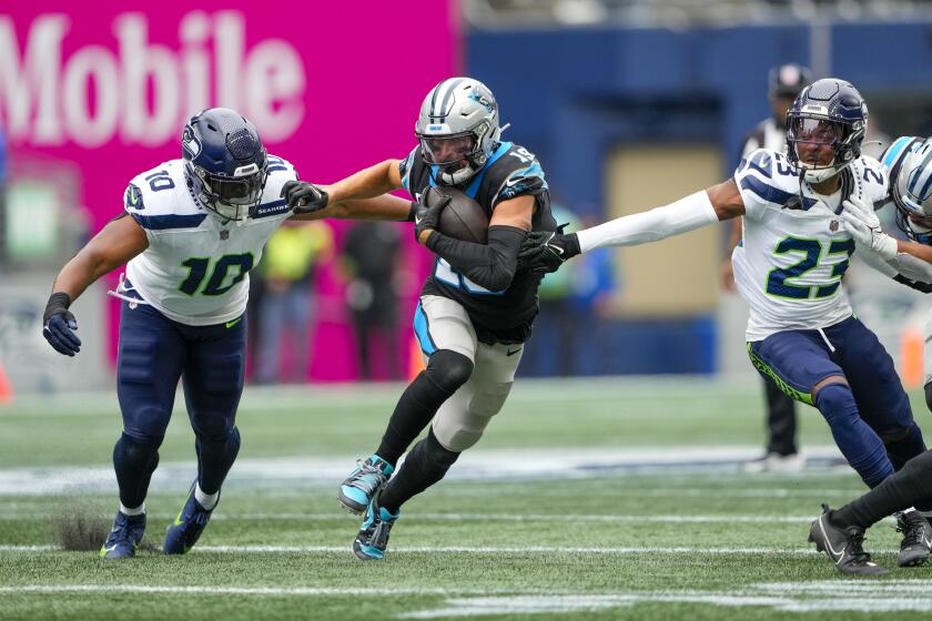 Carolina Panthers wide receiver Adam Thielen runs between Seattle Seahawks linebacker Uchenna Nwosu and cornerback Artie Burns (23) during the first half of an NFL football game Sunday, Sept. 24, 2023, in Seattle. (AP Photo/Lindsey Wasson)