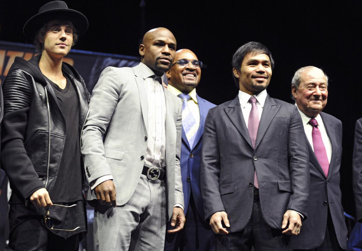 From left, Justin Bieber, Floyd Mayweather, Manny Pacquiao and Bob Arum pose for a photo during the press conference at the Nokia Theatre.