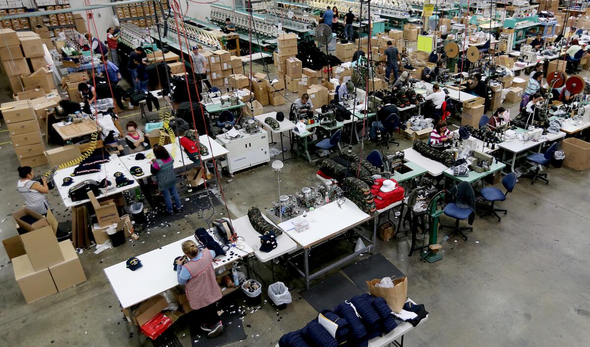 Workers stitch together hats on the factory floor of Cali-Fame in Carson.