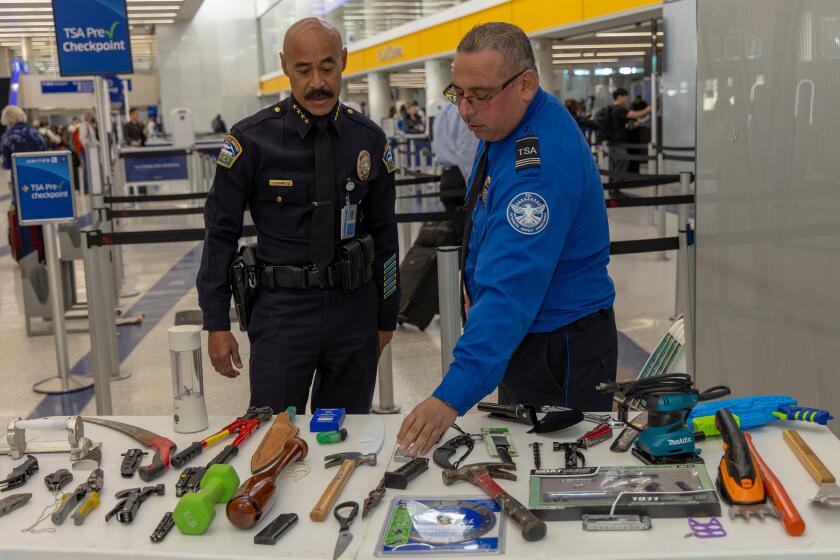 LOS ANGELES, CA - JANUARY 10: LAWA Police Chief Cecil Rhambo, left, and TSA supervisor Jorge Pineda display the items confiscated during TSA screening, at press conference held at Los Angeles International Airport on Wednesday, Jan. 10, 2024 in Los Angeles, CA. (Irfan Khan / Los Angeles Times)