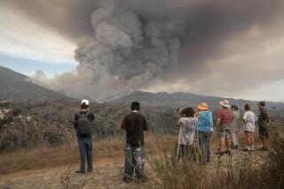 People watch the rapidly growing Airport fire burning in Trabuco Canyon as seen from Coyote Canyon trail, inside O'Neill Regional Park on Monday, Sept. 9, 2024.