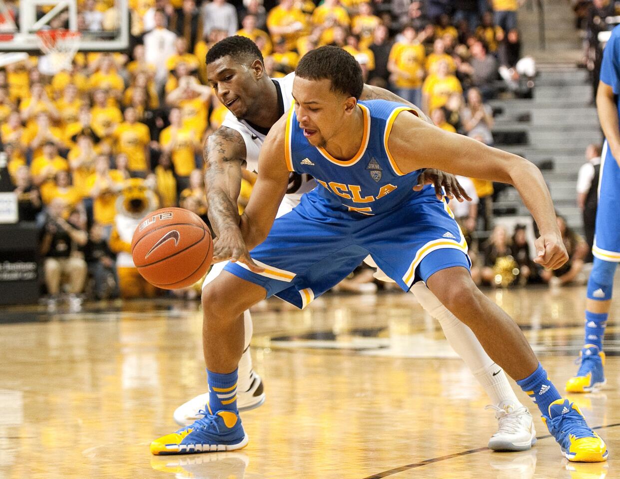 UCLA guard Kyle Anderson tries to control the ball as Missouri guard Earnest Ross takes a swipe at it in the second half Saturday.