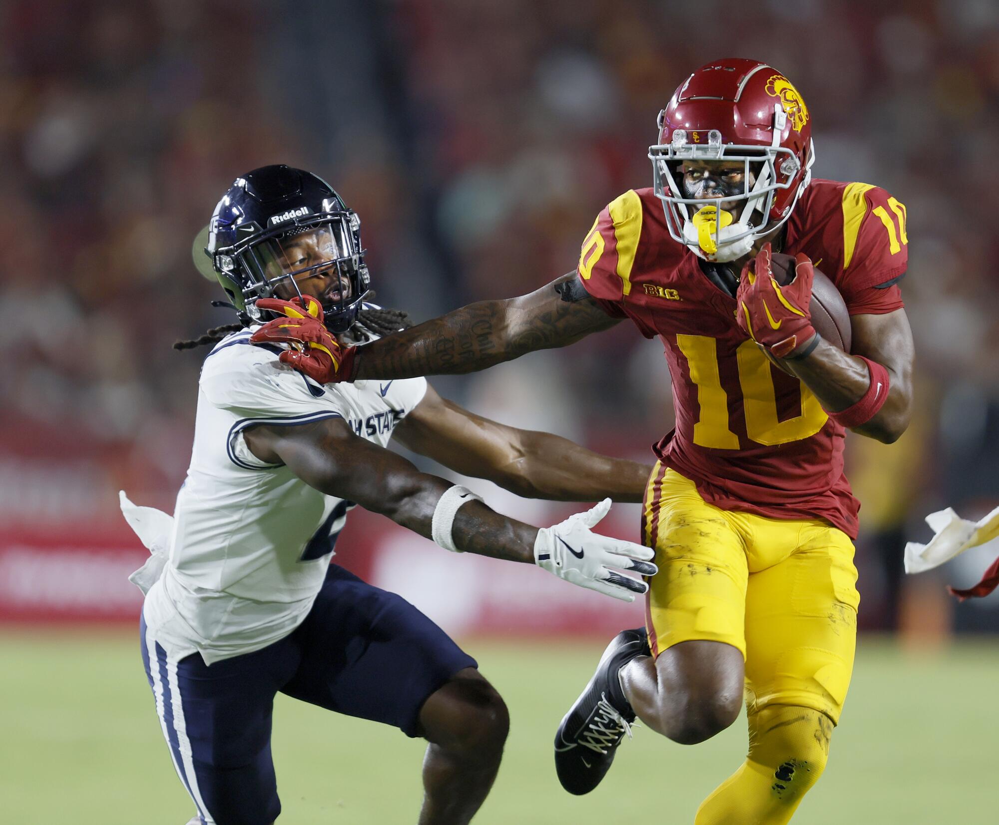 USC wide receiver Kyron Hudson pushes past Utah State cornerback Jaiden Francois.
