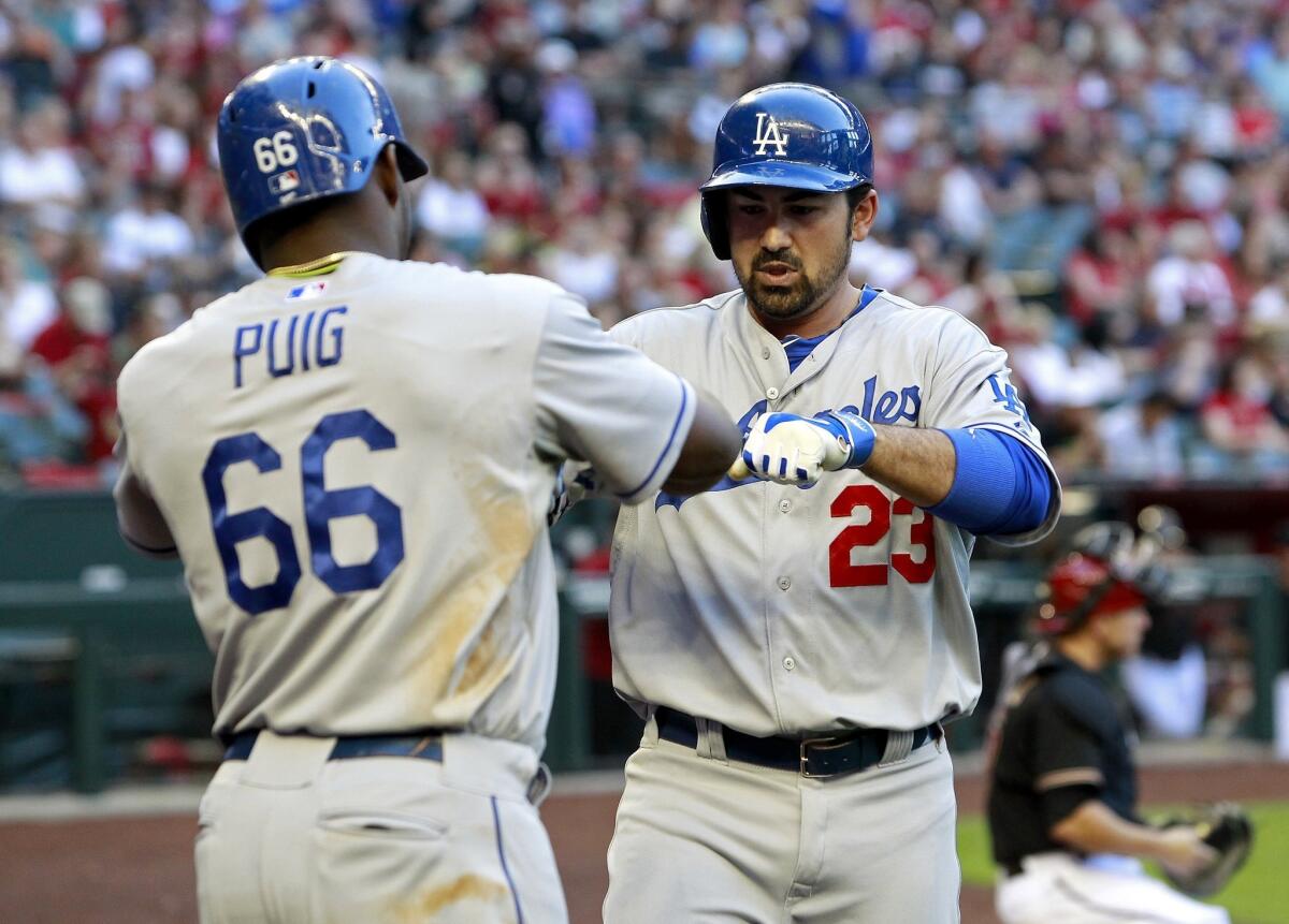 Dodgers first baseman Adrian Gonzalez is congratuled by right fielder Yasiel Puig after hitting a two-run home run against the Diamondbacks in the third inning Saturday night in Phoenix.
