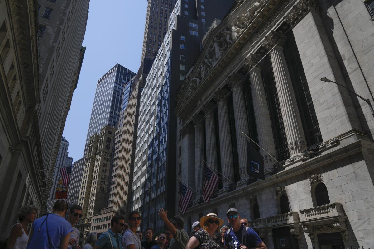 People walk around the front of the New York Stock Exchange in New York