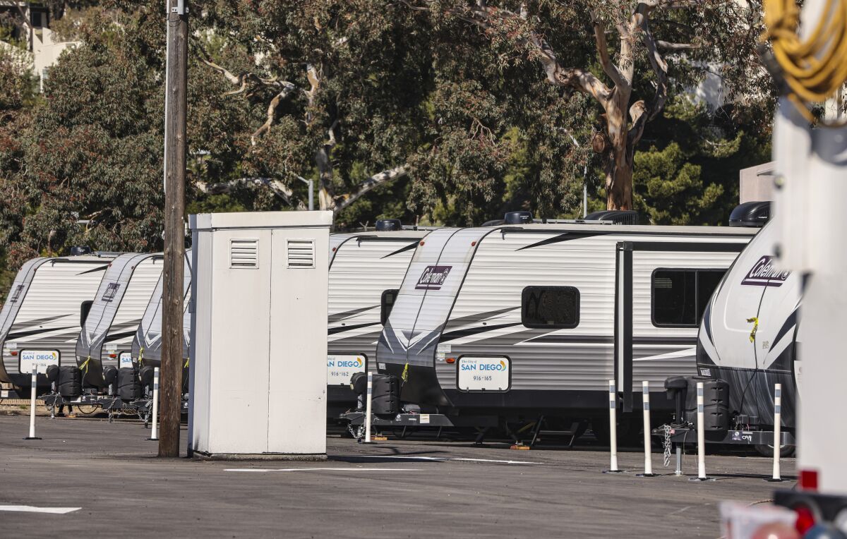 A row of camper-style trailers in a parking lot.