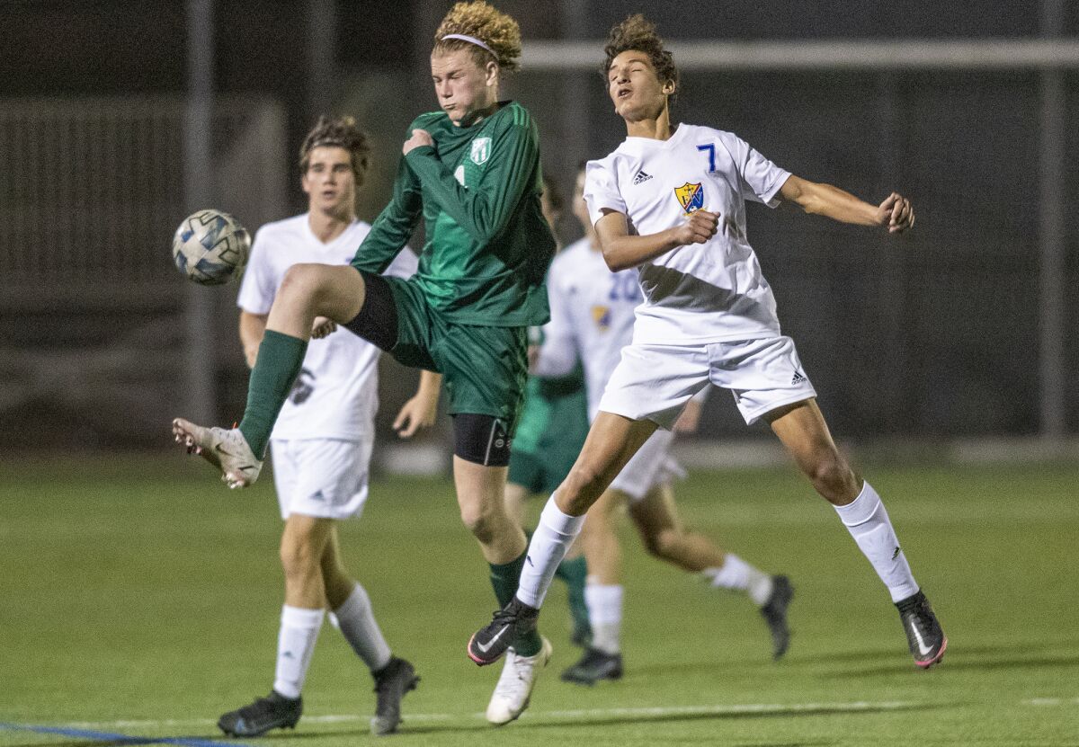 Edison's Scott Hess and Fountain Valley's Drew Payne go up for a ball during a Surf League boys' soccer match on Wednesday.