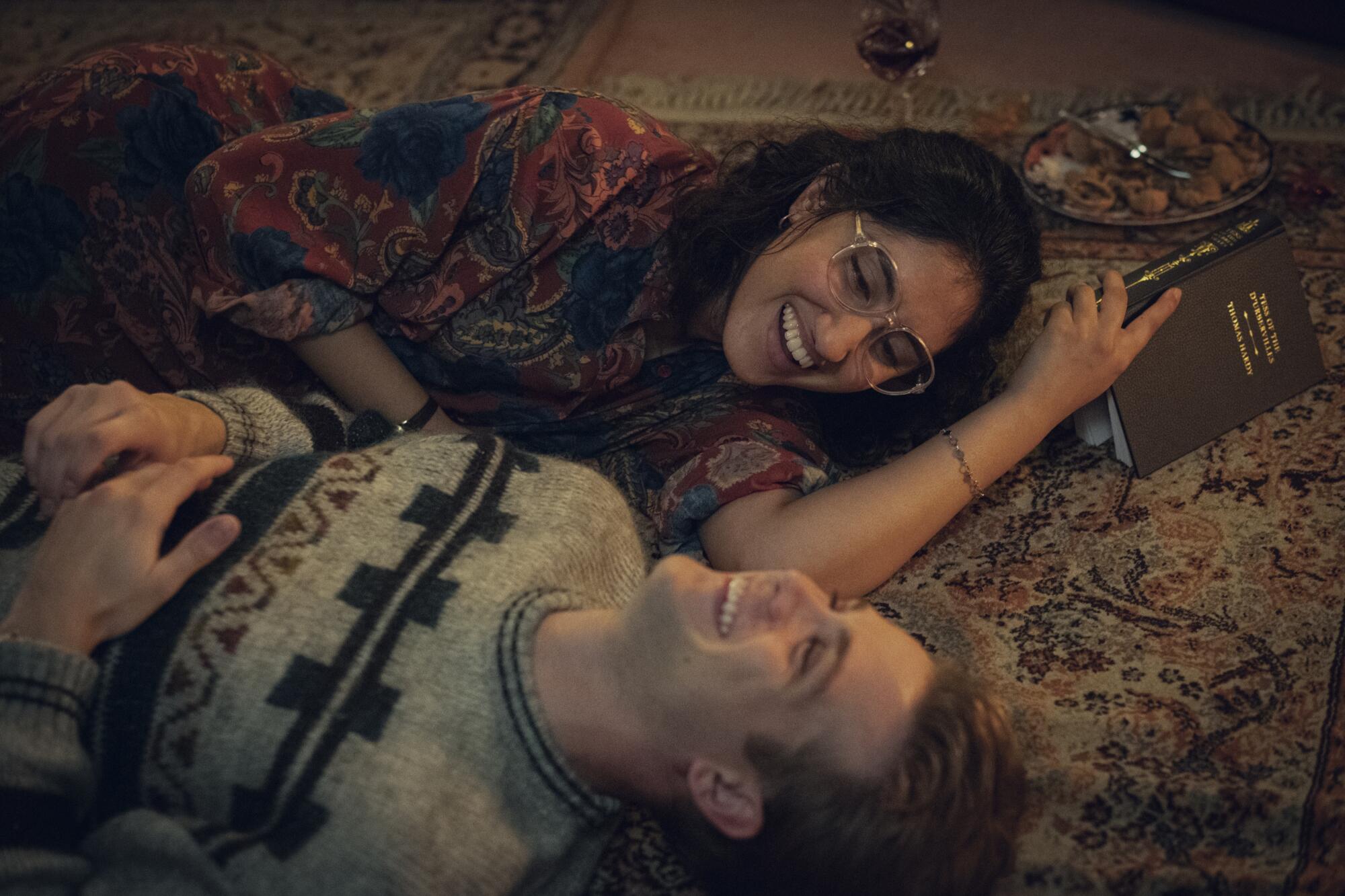 A couple laying on the carpet laughing