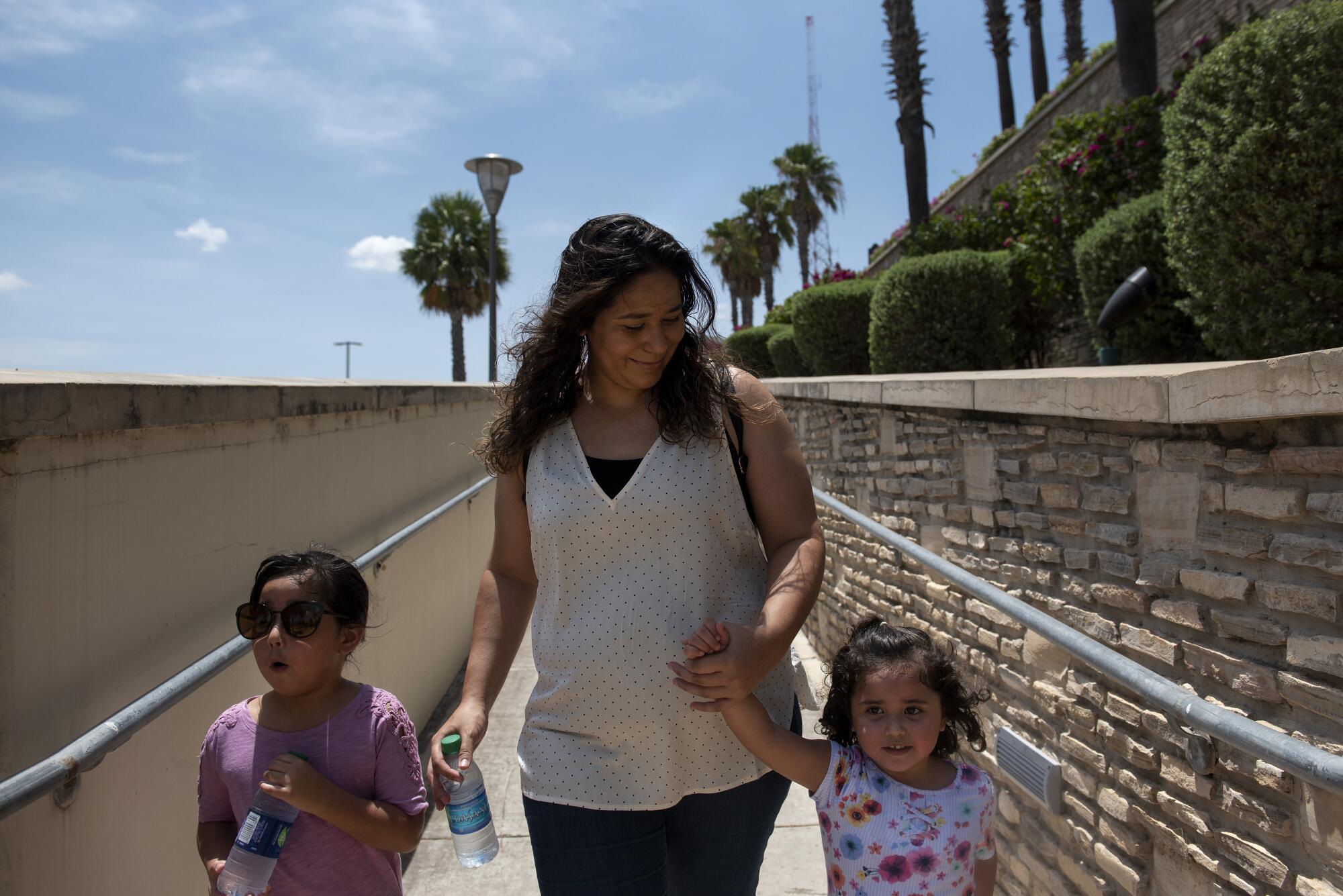 Ilse Mendez walks with her daughters Aaliyah, 5, and Aalizah, 3, at the outlet mall in Laredo, Texas.