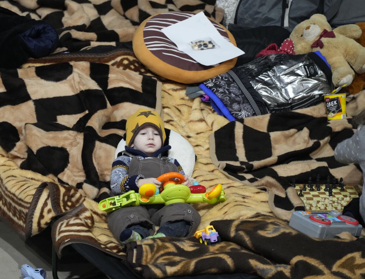 A boy holds a toy as he rests in a center for Ukrainian refugees in Warsaw, Poland, on Friday March 11, 2022. Warsaw has become overwhelmed by refugees, with more than a tenth of all those fleeing the war in Ukraine arriving in the Polish capital, and prompting Warsaw's mayor to appeal for international help. (AP Photo/Czarek Sokolowski)
