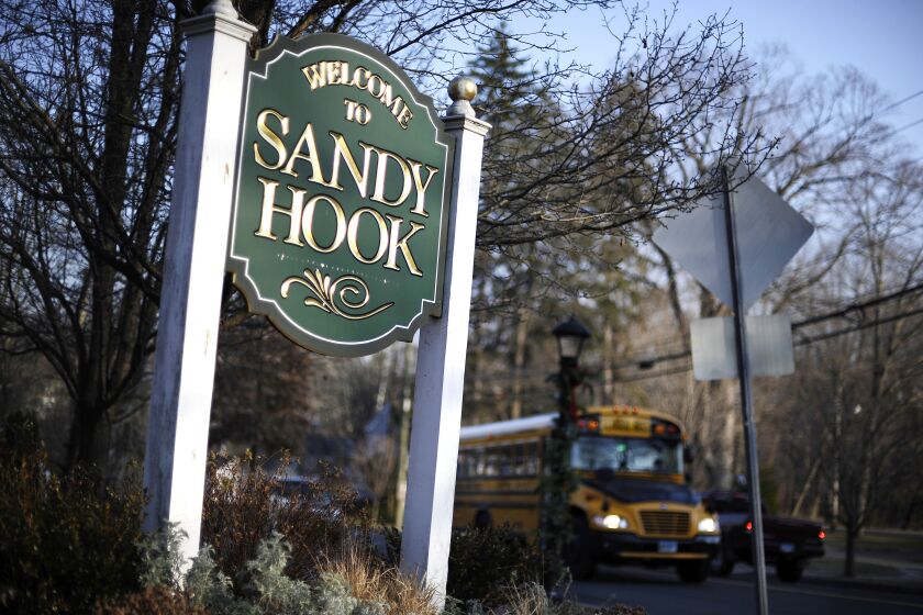 FILE - A bus drives past a sign reading Welcome to Sandy Hook in Newtown, Conn., Dec. 4, 2013. Connecticut Gov. Ned Lamont on Tuesday, June 6, 2023, signed the most wide-ranging state gun control bill since a 2013 law passed in the aftermath of the Sandy Hook Elementary School shooting, sparking an immediate lawsuit by gun rights supporters seeking to block a ban on open carrying and other parts of the new law. (AP Photo/Jessica Hill, File)