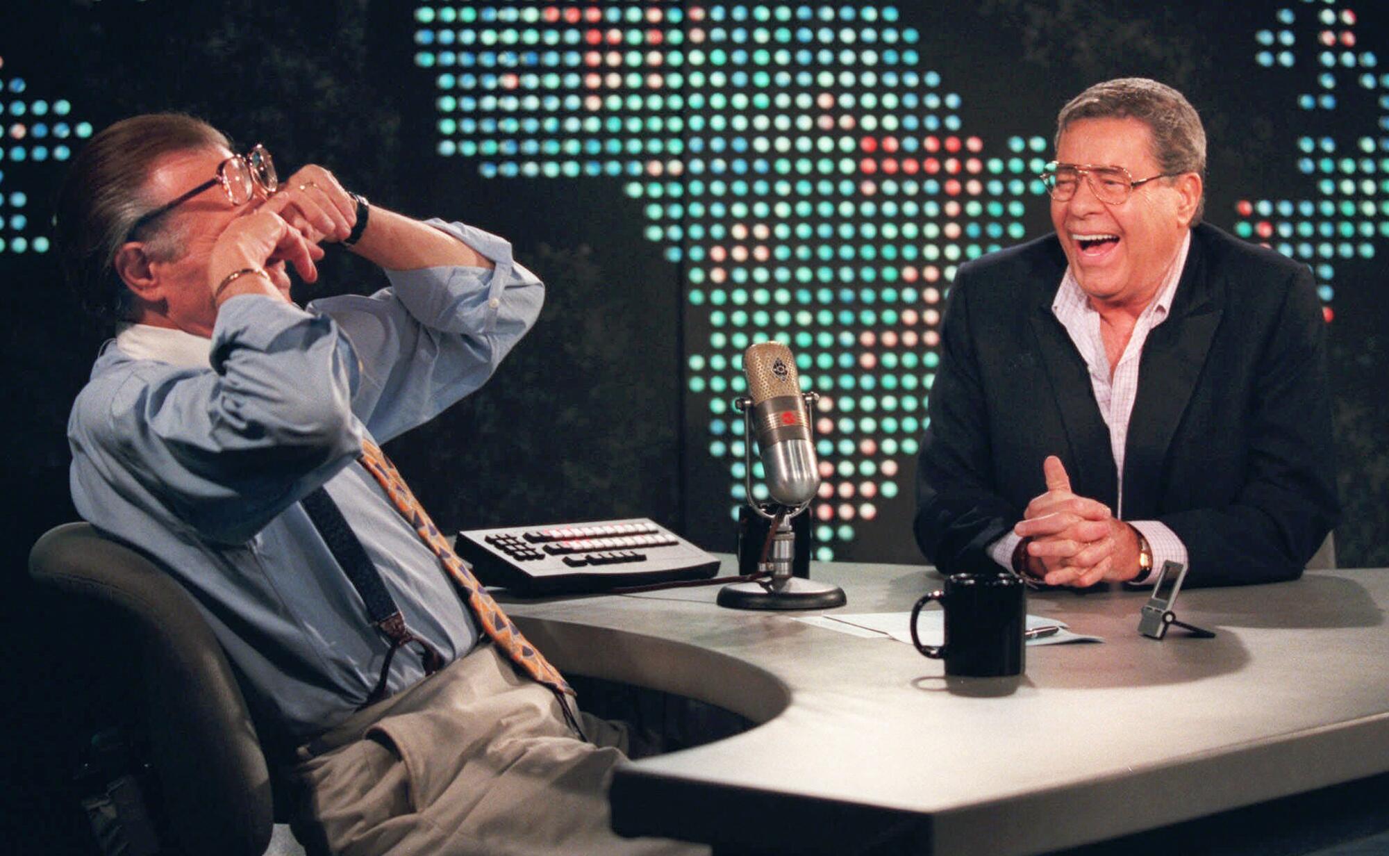 Talk show host Larry King wipes his eyes while laughing at a joke by comedy legend Jerry Lewis on set of "Larry King Live."