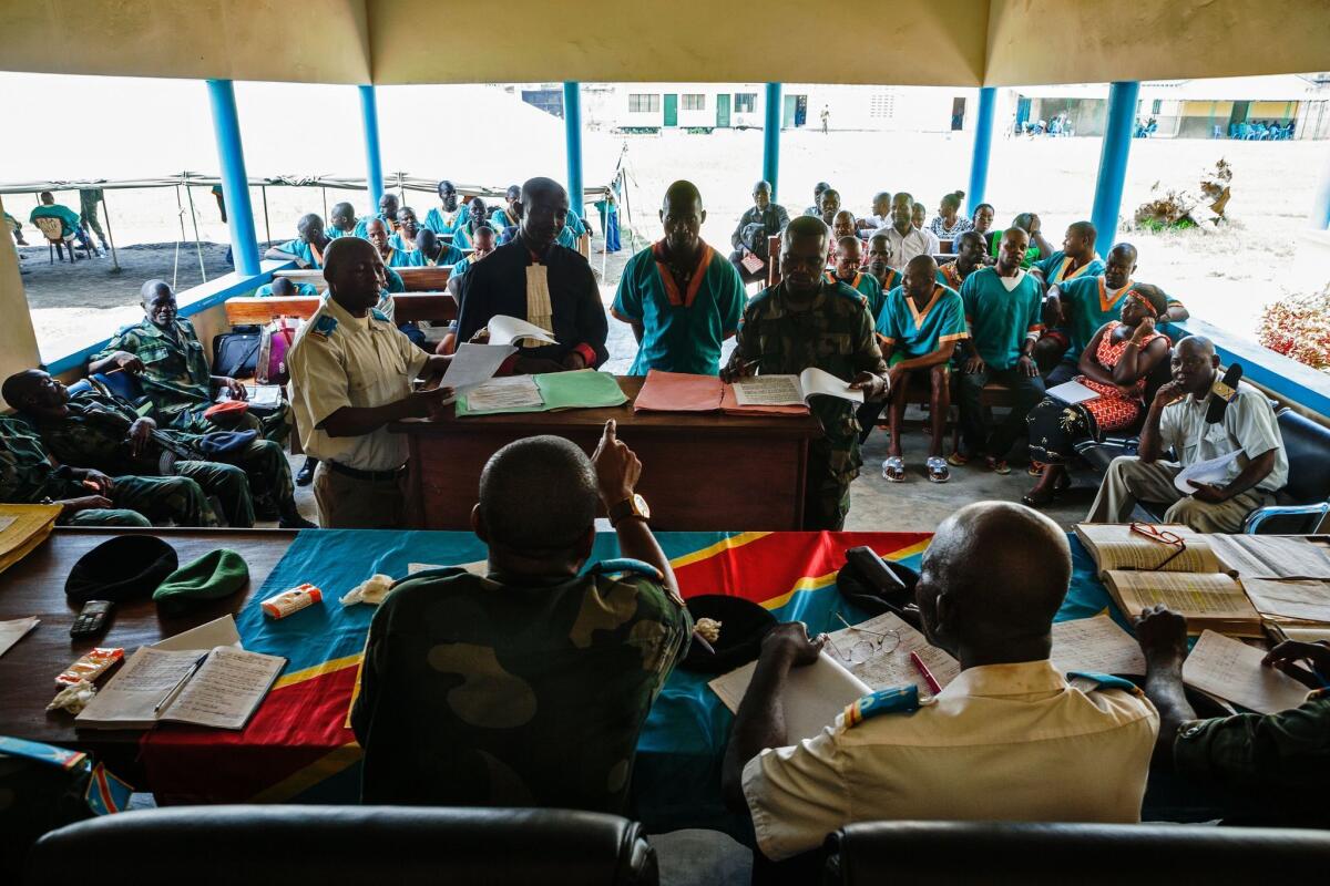Musenu Tshilayi, standing second from the right, a Congolese major sergeant accused of rape and violation of instructions, stands at the Military Tribunal of Kinshasa during the trial of Congolese MINUSCA (United Nations Multidimensional Integrated Stabilization Mission in the Central African Republic) soldiers on April 4, 2016. The trial against Congolese peacekeepers in the U.N. Mission in the Central African Republic involves 22 Congolese soldiers accused of rape-related violations.