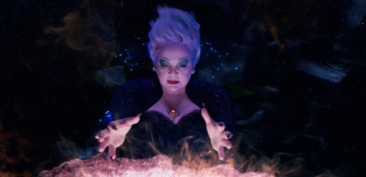 Melissa McCarthy as Ursula holding her hands over a steaming cauldron in a still from 'The Little Mermaid'