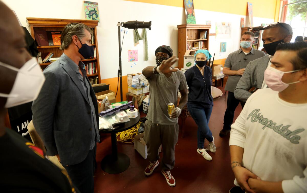 California Governor Gavin Newsom, second from left, listens to the concerns of Marcus Warren.
