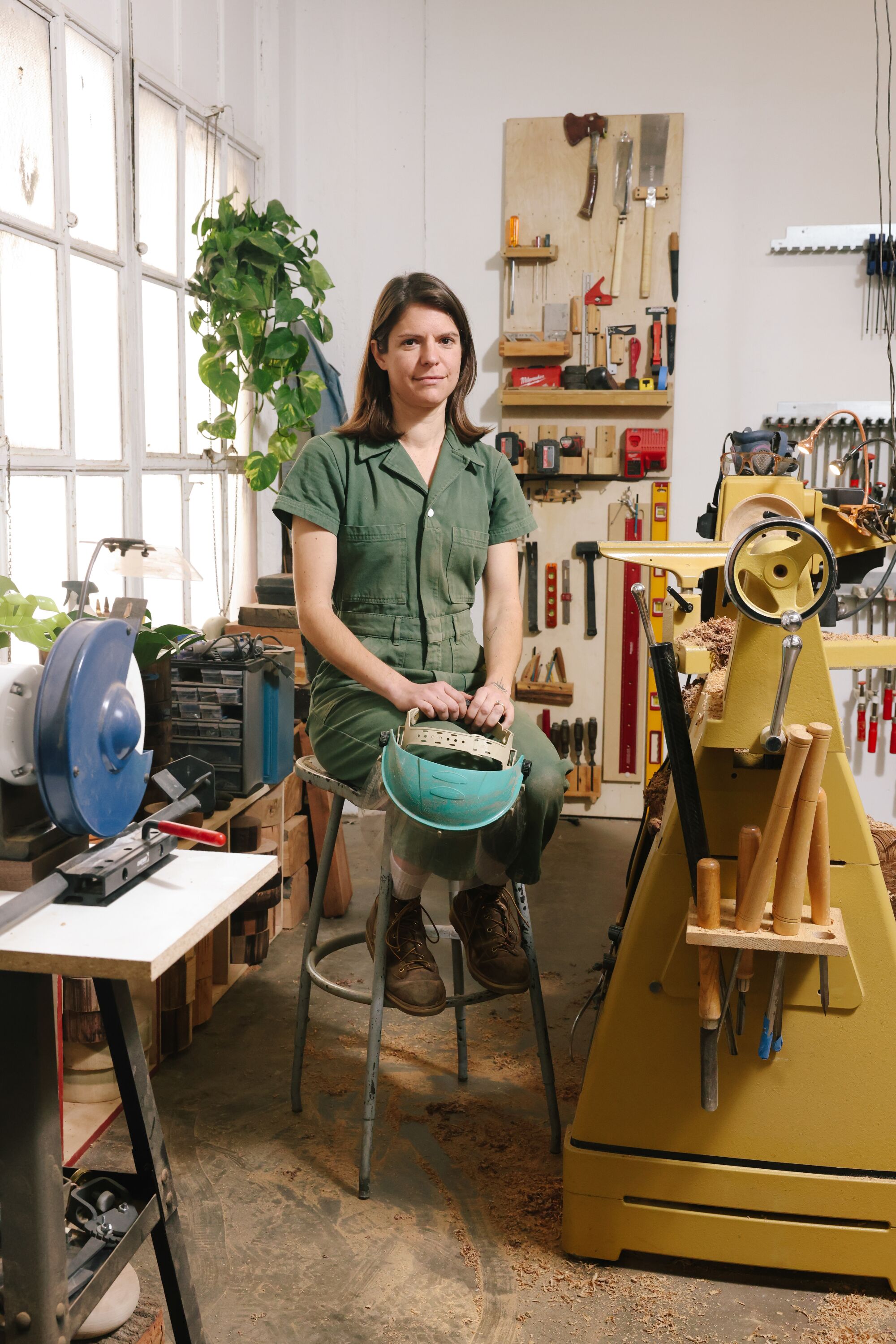 a woman sits in a woodshop 