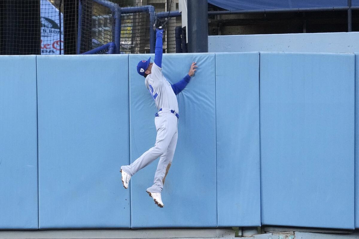Chicago Cubs center fielder Cody Bellinger makes a leaping catch to prevent a home run.