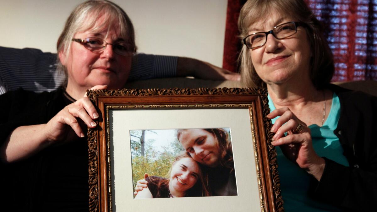 In this June 4, 2014, photo, mothers Linda Boyle, left, and Lyn Coleman hold a photo of their married children, Joshua Boyle and Caitlan Coleman, who were kidnapped by the Taliban in late 2012.