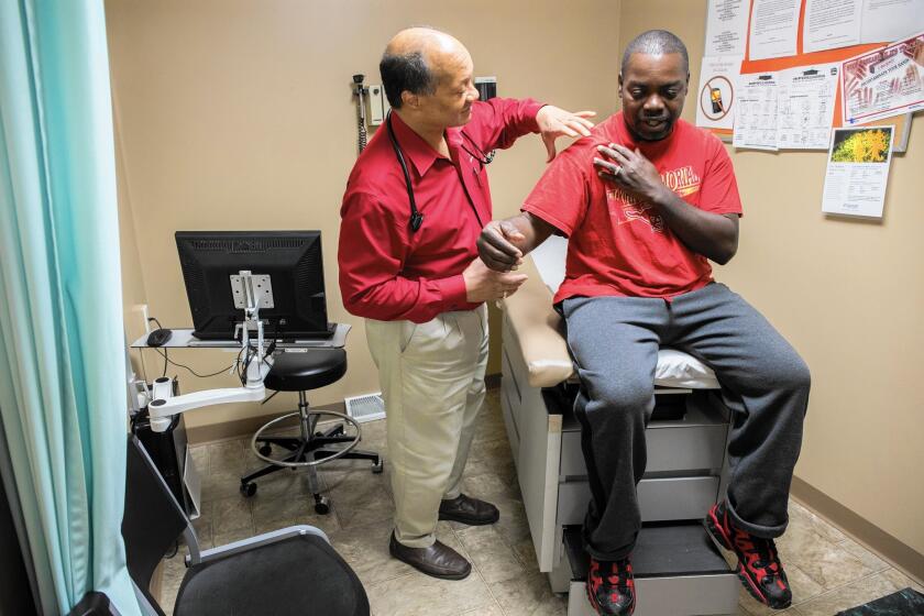 Dr. James Jackson performs a physical on Matthew Shorter, 51, a Medicaid patient enrolled in the Healthy Indiana Plan, at the Heart City Health Center in Elkhart.