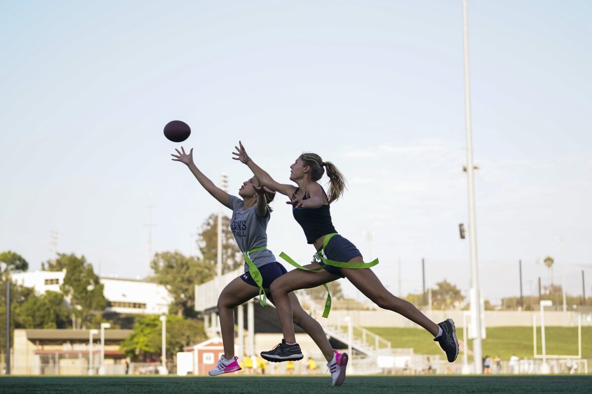 Syndel Murillo, 16, left, and Shale Harris, 15, reach for a pass as they try out for the Redondo Union High School girls flag football team on Thursday, Sept. 1, 2022, in Redondo Beach, Calif. Southern California high school sports officials will meet on Thursday, Sept. 29, to consider making girls flag football an official high school sport. This comes amid growth in the sport at the collegiate level and a push by the NFL to increase interest. (AP Photo/Ashley Landis)