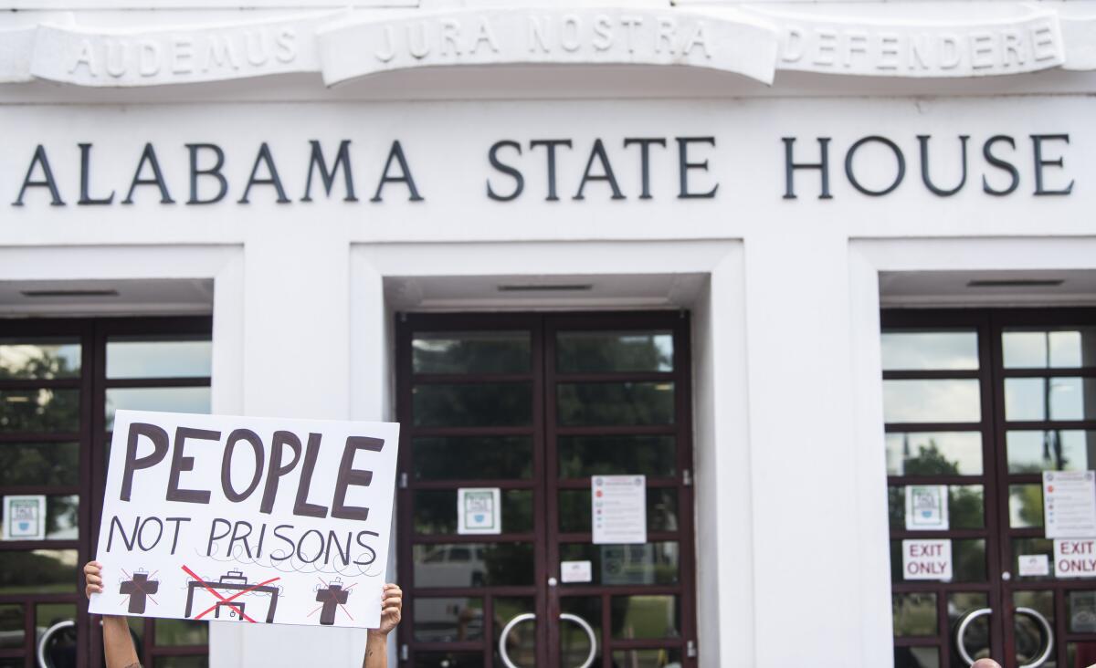 People protest the prison plan outside the Alabama State House.