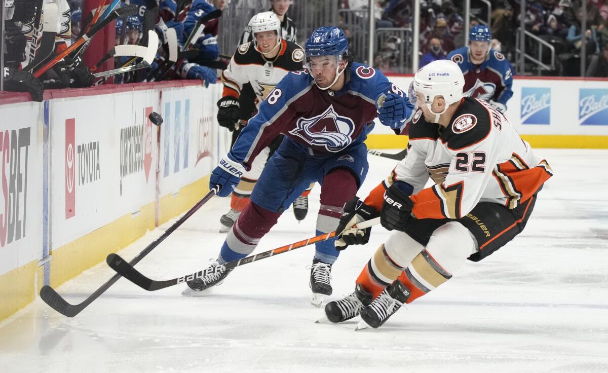 Colorado Avalanche center Alex Newhook, left, and Ducks defenseman Kevin Shattenkirk chase the puck.