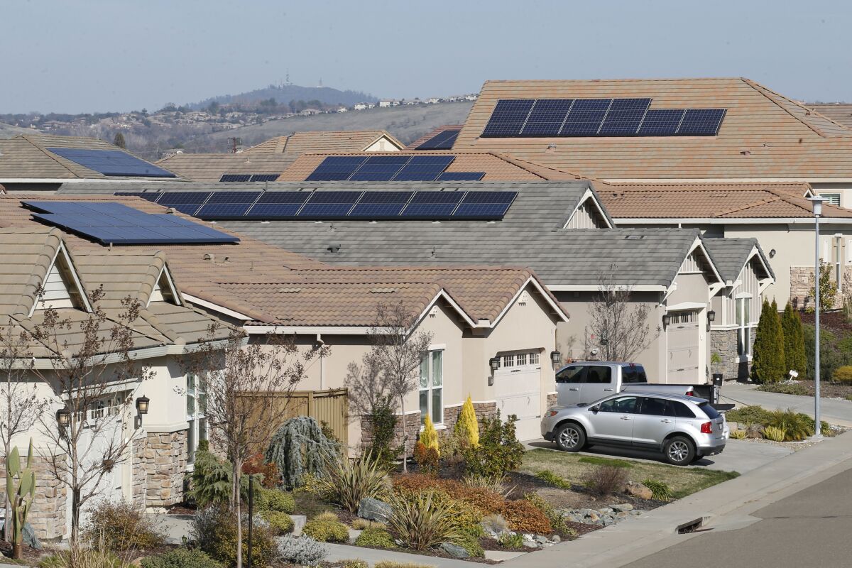 FILE - This photo taken Wednesday, Feb. 12, 2020, shows solar panels on rooftops of a housing development in Folsom, Calif. State regulators at the California Public Utilities Commission are expected to propose reforms that would lower the financial incentives for homeowners who install solar panels. (AP Photo/Rich Pedroncelli, File)