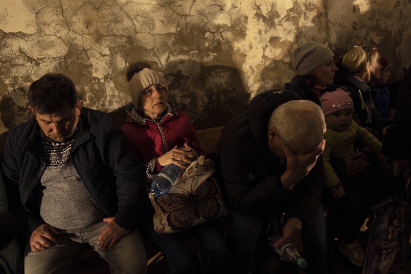 People huddle in a basement for shelter in Ukraine.